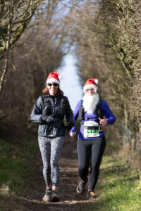 Two LAC runners in festive attire enjoy the 3rd Annual Lewes Downland Santa Run | Lewes Athletic Club